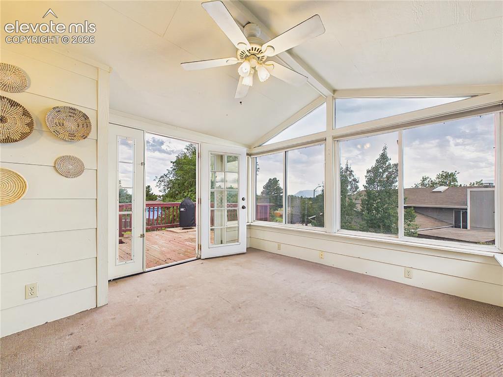 Image 19 of 50: Bright enclosed sunroom surrounded by expansive windows, creating a versati