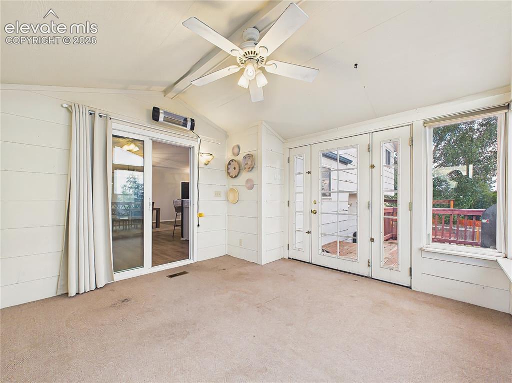 Image 20 of 50: Sun-filled enclosed sunroom with vaulted ceiling, large picture windows, an