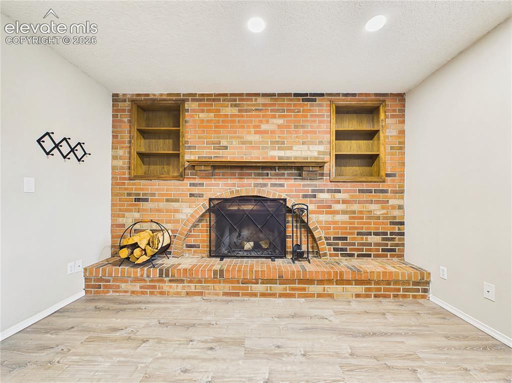 Image 25 of 50: Inviting family room centered around a floor-to-ceiling brick fireplace wit