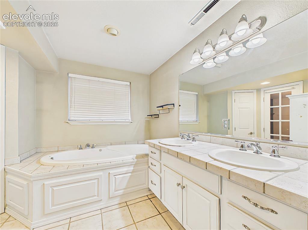 Image 32 of 50: Well-appointed primary bathroom with dual sinks, generous vanity space, and