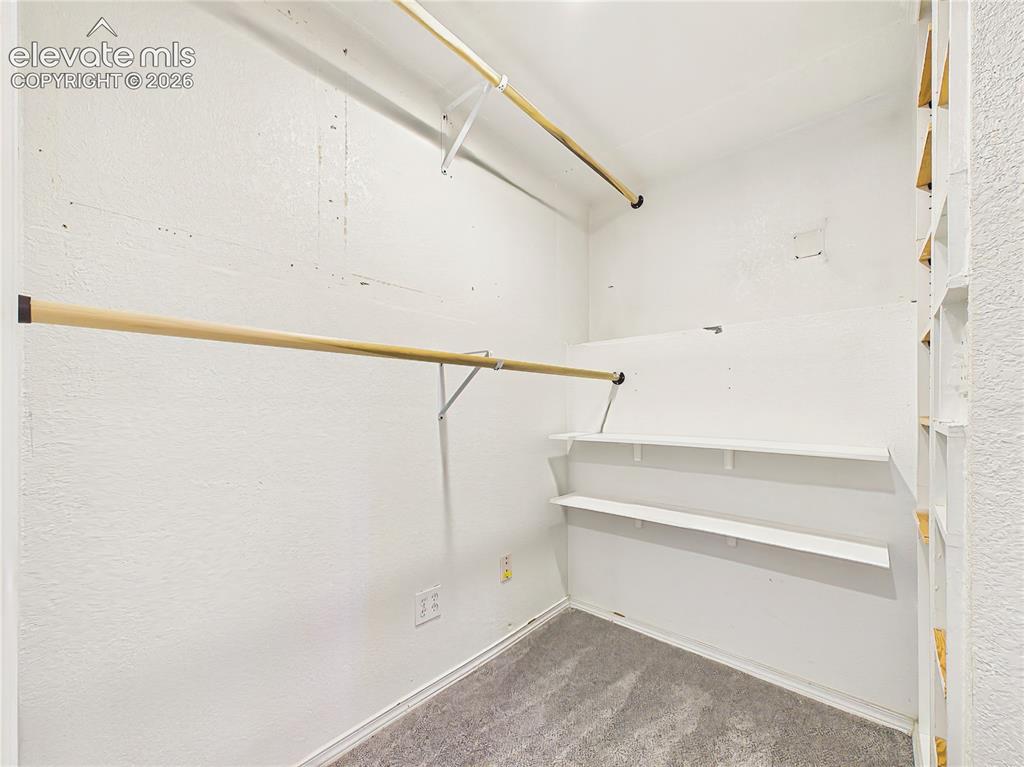 Image 35 of 50: Expansive walk-in closet with built-in shelving and abundant hanging space,