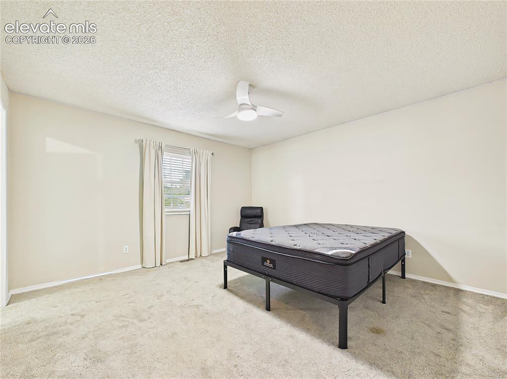 Image 36 of 50: Bright and comfortable primary suite with a large window, updated ceiling f