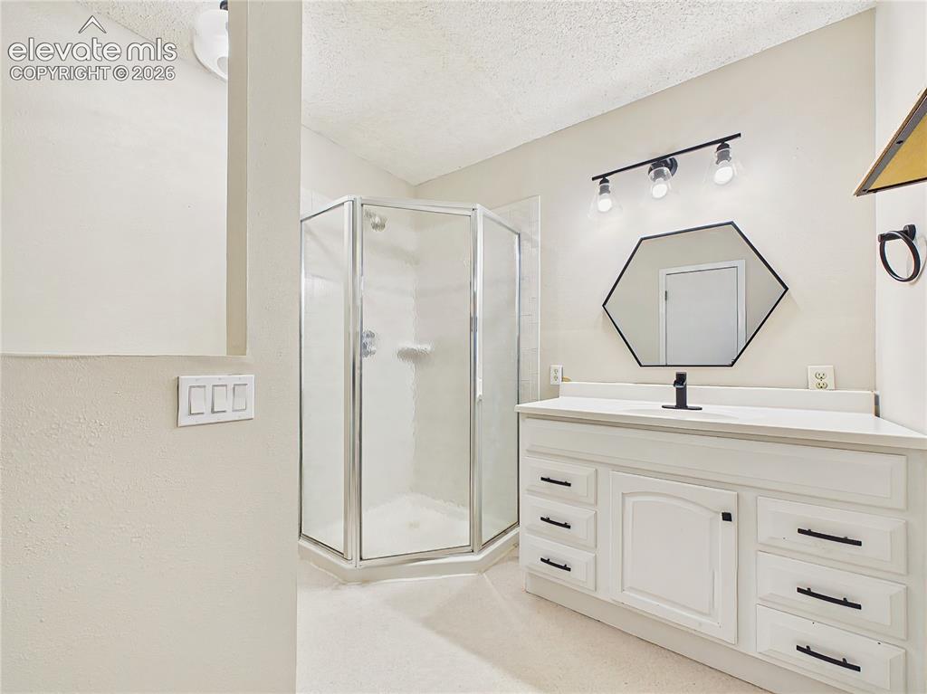 Image 39 of 50: Updated primary bathroom featuring a modern vanity, stylish lighting, and a