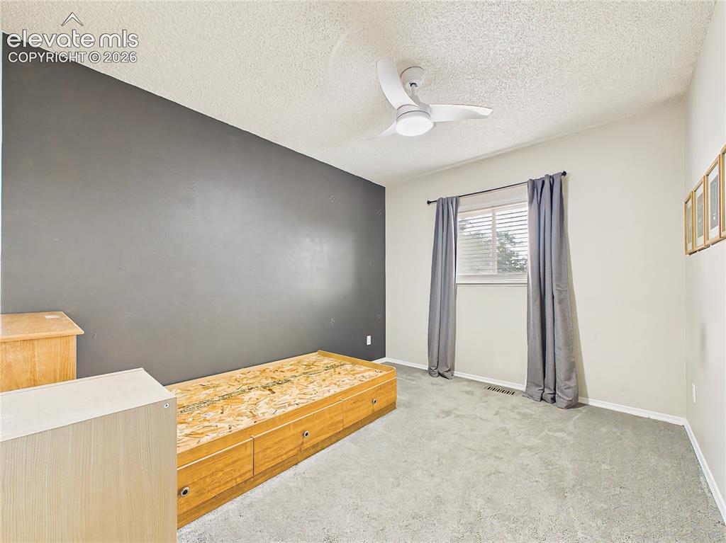 Image 42 of 50: Comfortable secondary bedroom with neutral finishes, an accent wall, and fl