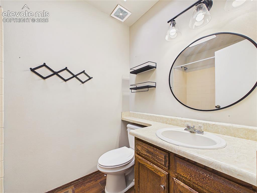 Image 43 of 50: Updated bathroom with a modern round mirror, stylish lighting, and a spacio