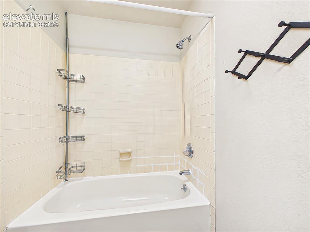 Image 44 of 50: Full bathroom featuring a tub/shower combination with classic tile surround