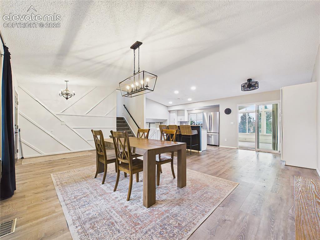 Image 6 of 50: Spacious dining area with contemporary lighting, durable luxury vinyl plank