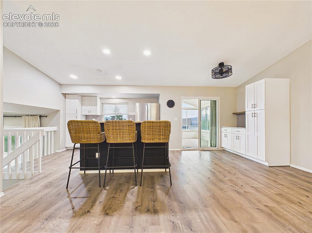 Image 9 of 50: Renovated kitchen featuring a generous center island with seating, white ca