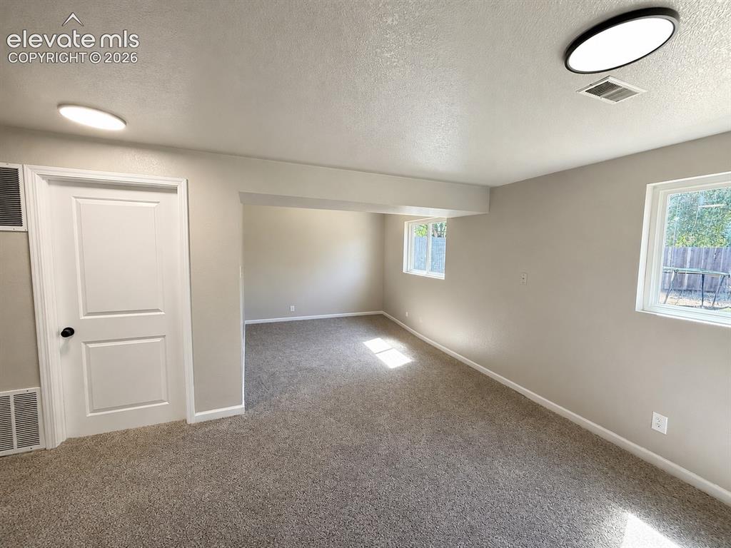 Image 21 of 30: lowere level living room currently used as bedroom