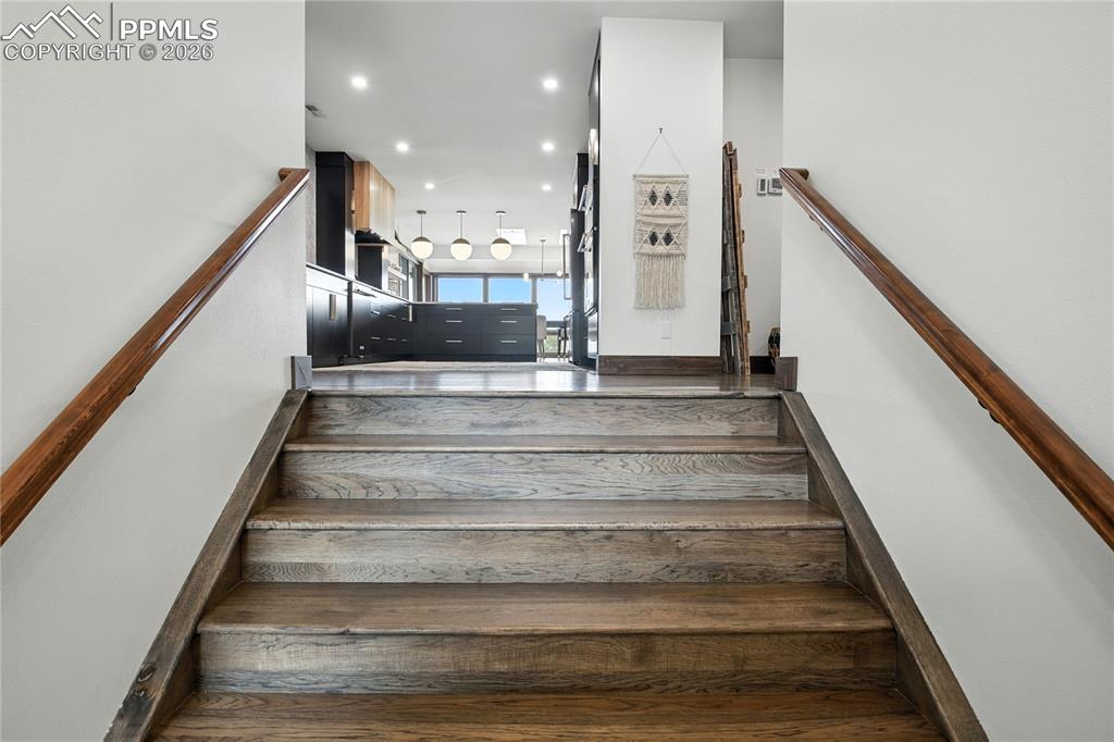 Image 8 of 50: Stairs with hardwood / wood-style floors and recessed lighting