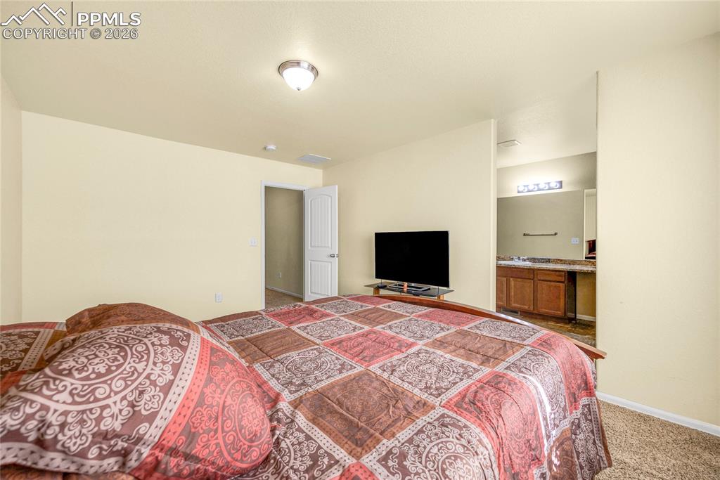 Image 16 of 32: Primary suite features soft color tones, open layout, and abundant natural 