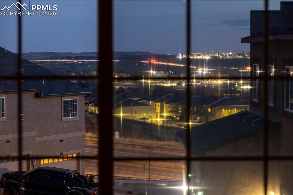 Image 17 of 32: Captured city-light view from the primary bedroom — a peaceful night backdr