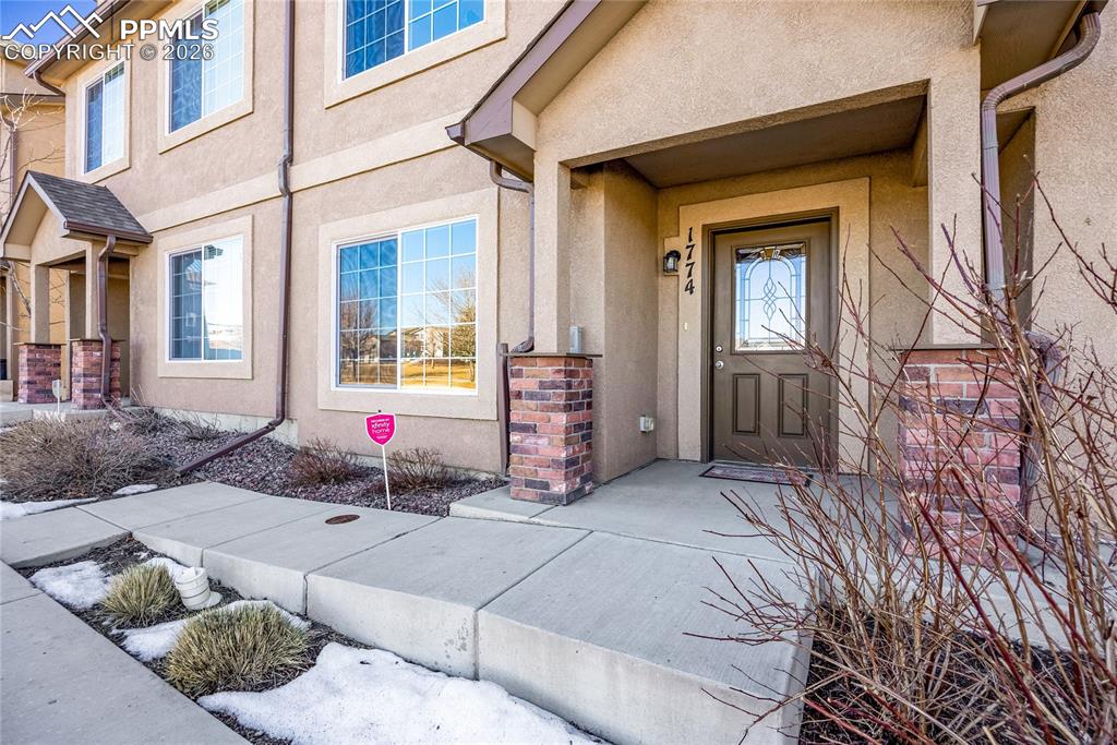 Image 2 of 32: Inviting covered entry with brick accents and welcoming walkway.