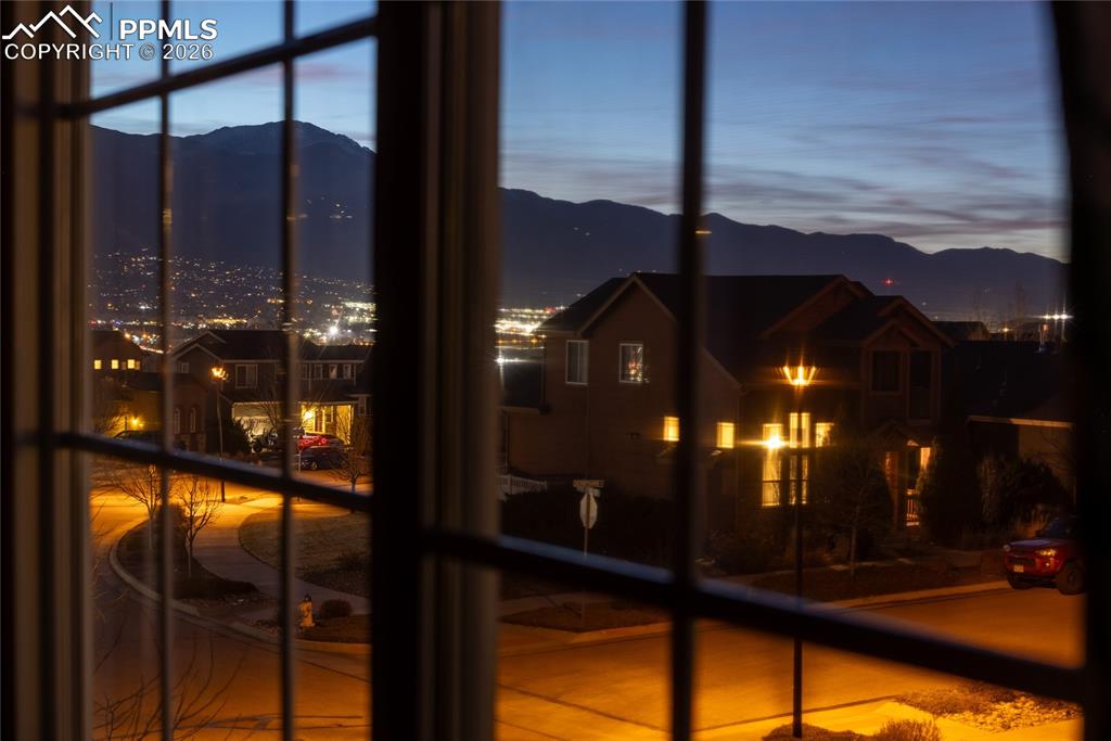 Image 22 of 32: Evening view of Pikes Peak and neighborhood lights from upstairs window.
