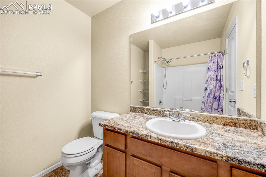 Image 23 of 32: Bright full bath featuring granite countertop, updated fixtures, and shower