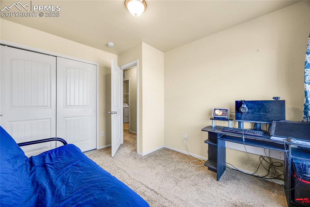 Image 25 of 32: Bedroom with an office area, light carpet, and a closet