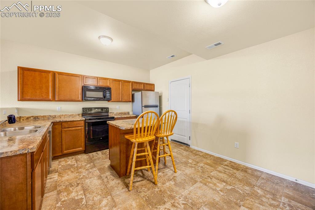 Image 8 of 32: Open kitchen with center island and breakfast seating — perfect for everyda
