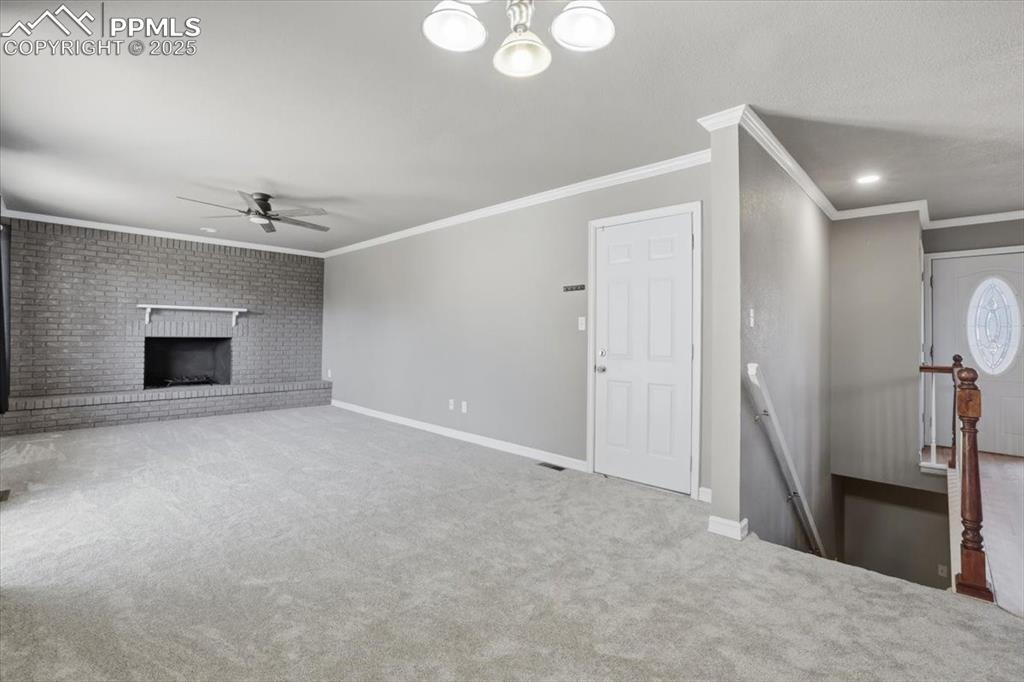 Image 19 of 48: Unfurnished living room with carpet floors, crown molding, ceiling fan, a b