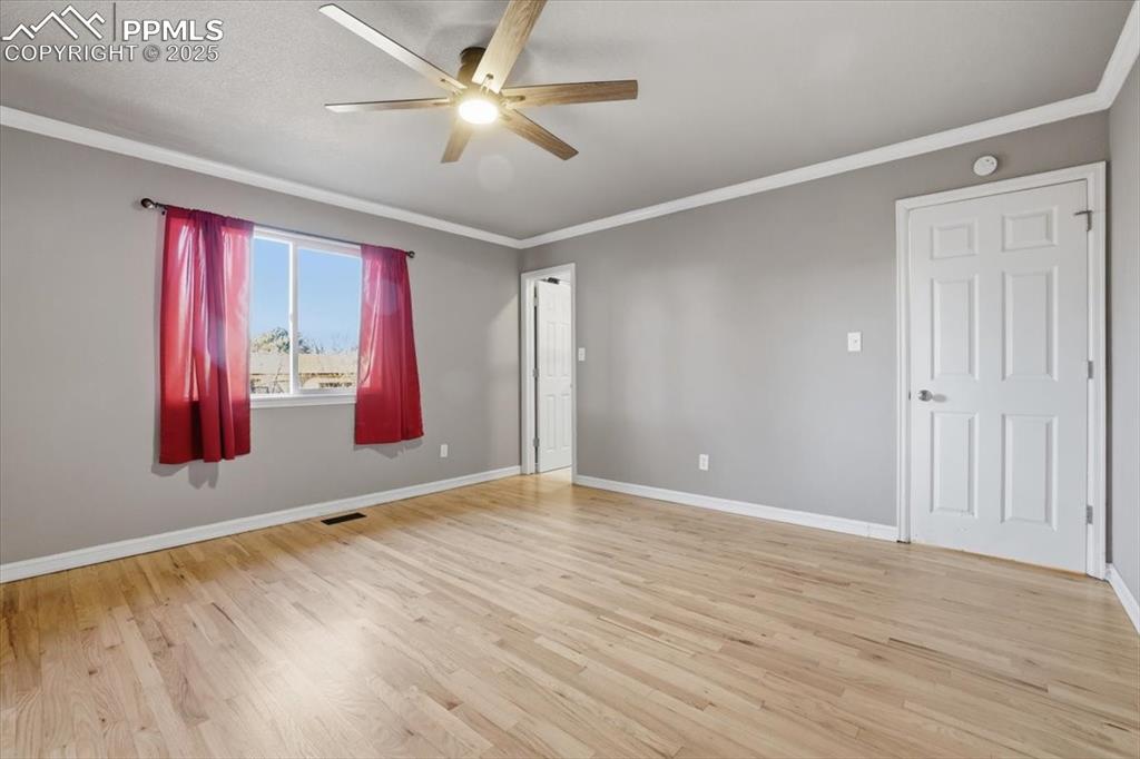 Image 23 of 48: Spare room featuring ornamental molding, light wood finished floors, and a 