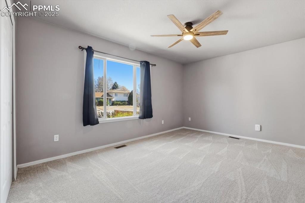 Image 26 of 48: Spare room featuring light carpet and ceiling fan