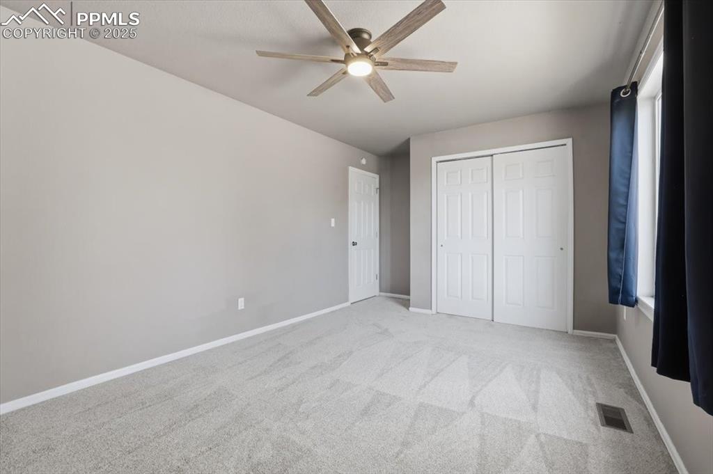 Image 27 of 48: Unfurnished bedroom with light carpet, a ceiling fan, and a closet