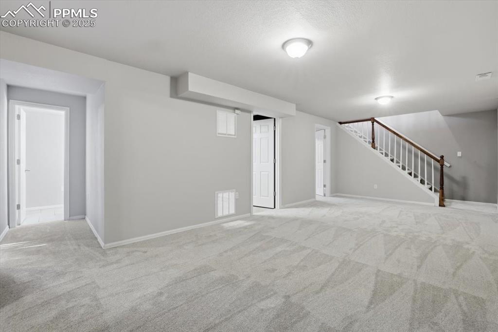 Image 29 of 48: Basement featuring carpet floors and stairway
