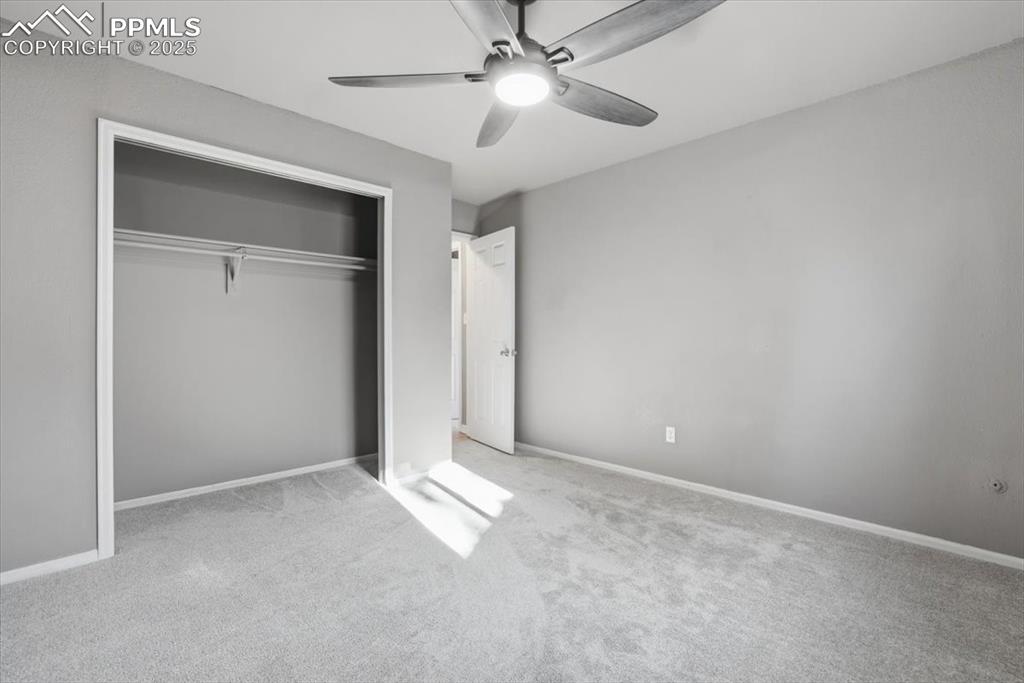 Image 31 of 48: Unfurnished bedroom featuring carpet floors, ceiling fan, and a closet