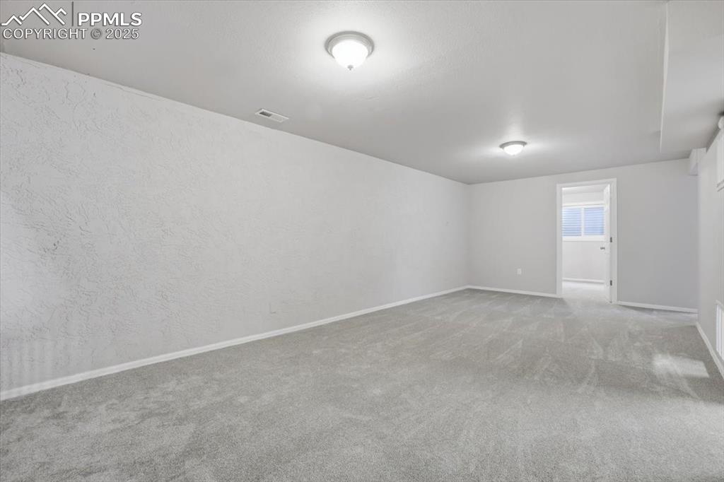 Image 32 of 48: Spare room featuring carpet floors and a textured wall