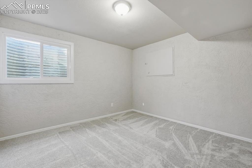 Image 33 of 48: Carpeted spare room with a textured wall and baseboards