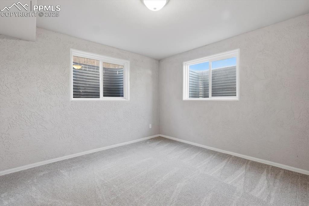 Image 37 of 48: Carpeted spare room featuring a textured wall and baseboards