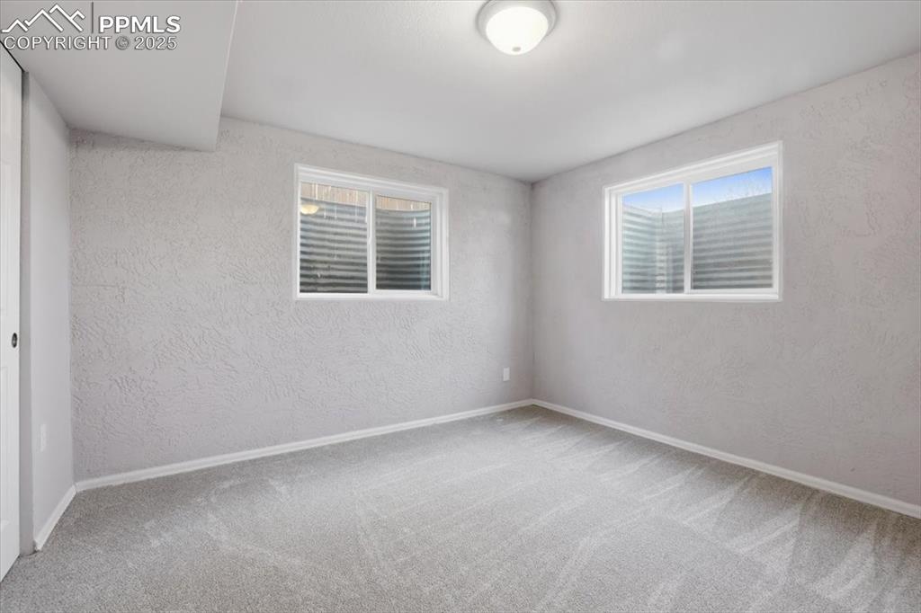 Image 38 of 48: Spare room featuring a textured wall and carpet flooring