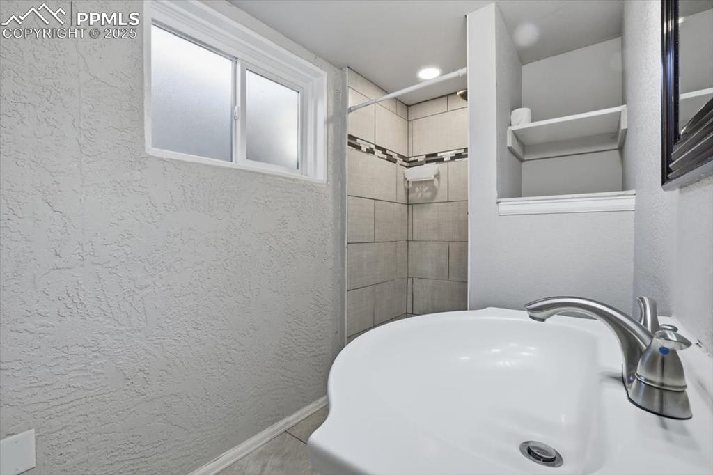 Image 41 of 48: Bathroom featuring and tiled shower & storage