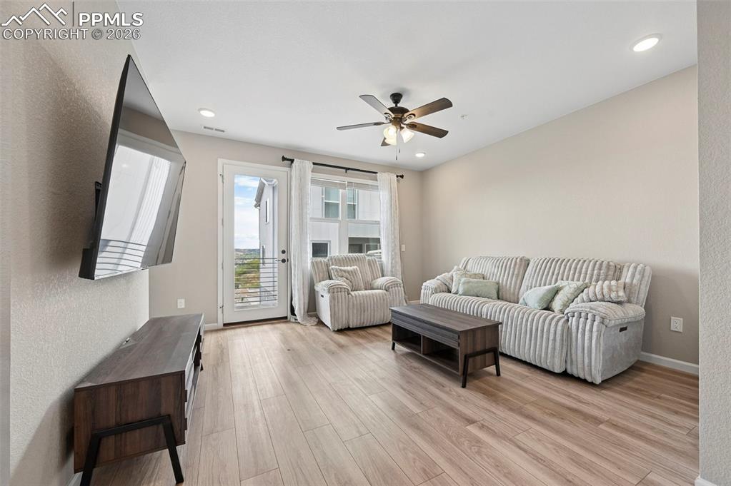 Image 10 of 42: Light wood-finish flooring complements the neutral wall color