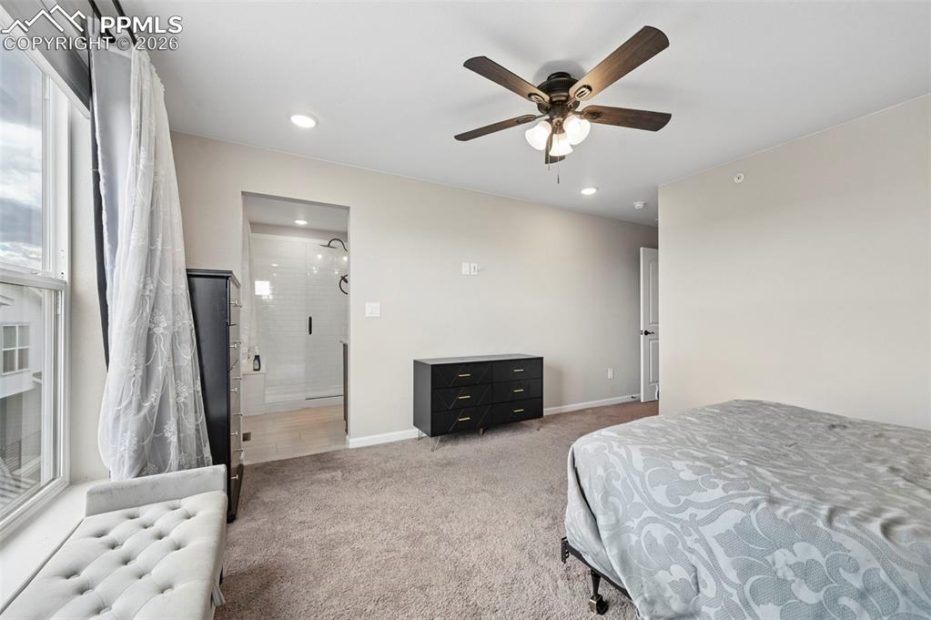 Image 16 of 42: Carpeted bedroom with a ceiling fan light fixture and recessed lighting