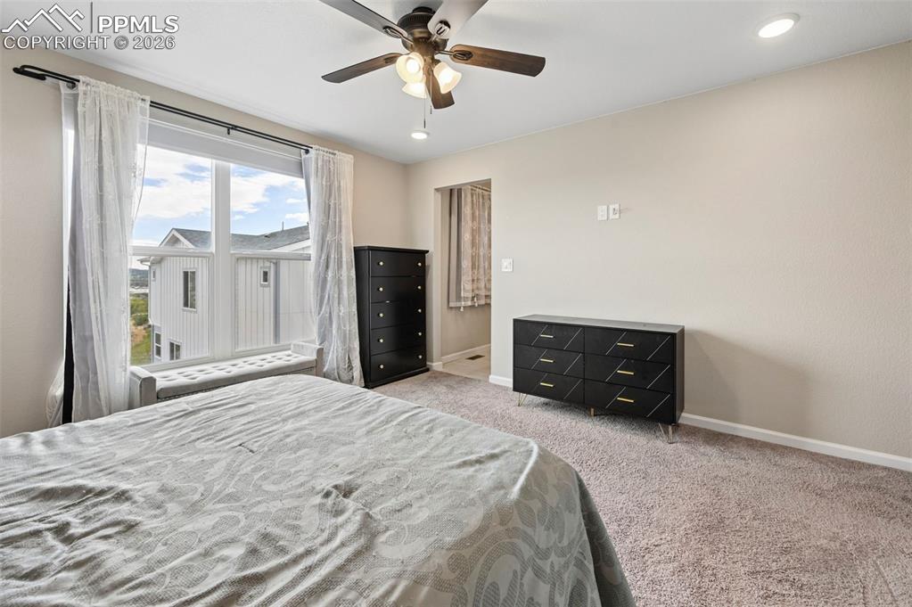 Image 17 of 42: Carpeted room featuring a large window with a window seat, ceiling fan, and