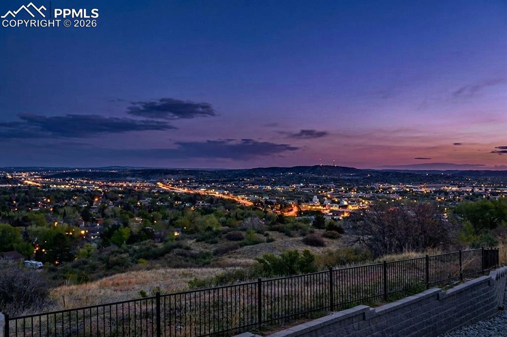 Image 2 of 42: Expansive cityscape with distant city lights under a twilight sky