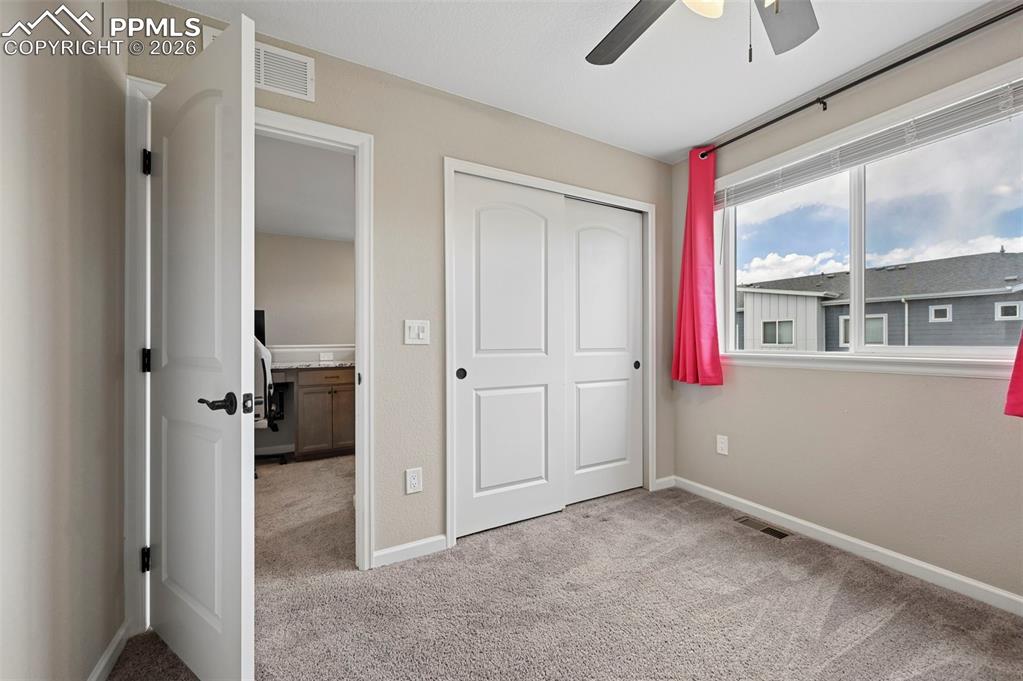 Image 20 of 42: Carpeted interior room featuring a ceiling fan, a window with exterior view