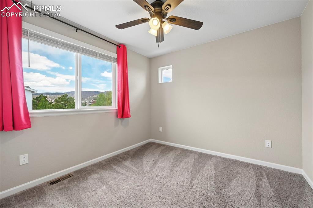 Image 21 of 42: Room featuring a large picture window, a smaller high-set window, neutral w