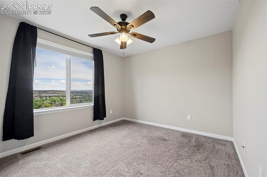 Image 22 of 42: Room featuring a large window with a distant landscape, neutral wall tones,