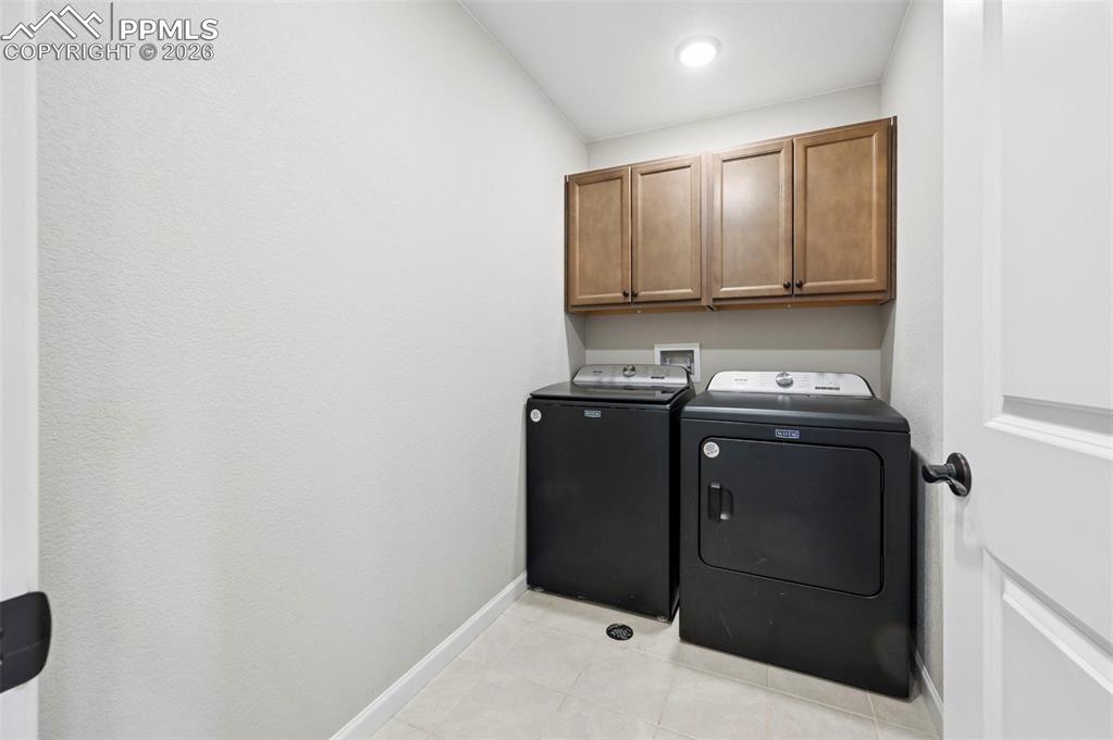 Image 29 of 42: Dedicated utility space featuring light-toned tile flooring, recessed ceili