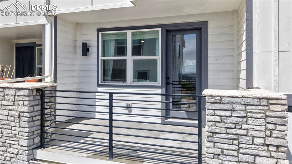 Image 3 of 42: Outdoor patio area featuring a metal railing and stone pillars