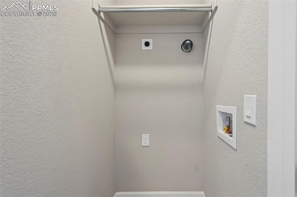 Image 30 of 42: Dedicated laundry area featuring a wall-mounted drying rod, recessed applia