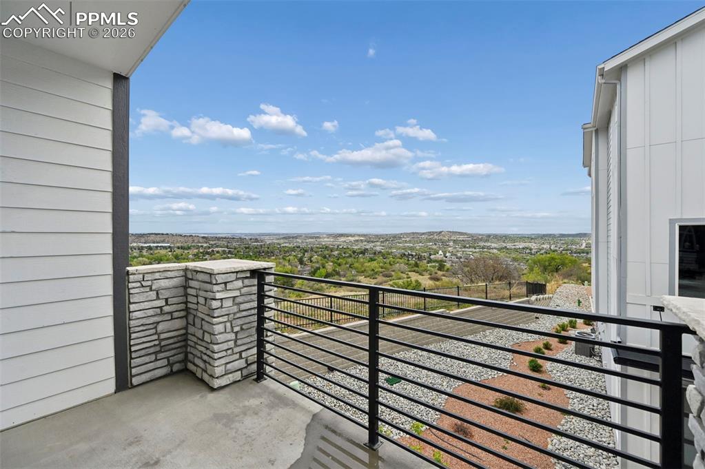 Image 33 of 42: Balcony featuring concrete flooring, a stone-clad half-wall, and a black ho