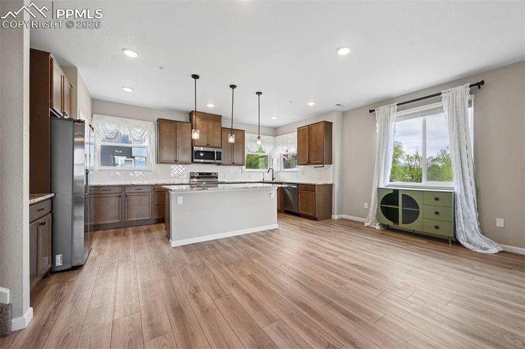 Image 4 of 42: Open-concept kitchen and living area featuring wood-finish flooring, recess