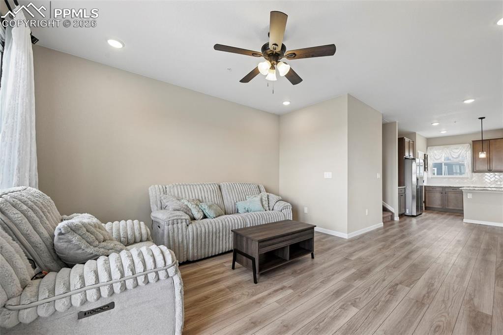 Image 8 of 42: Open-concept living area with wood-finish flooring, recessed lighting, and 