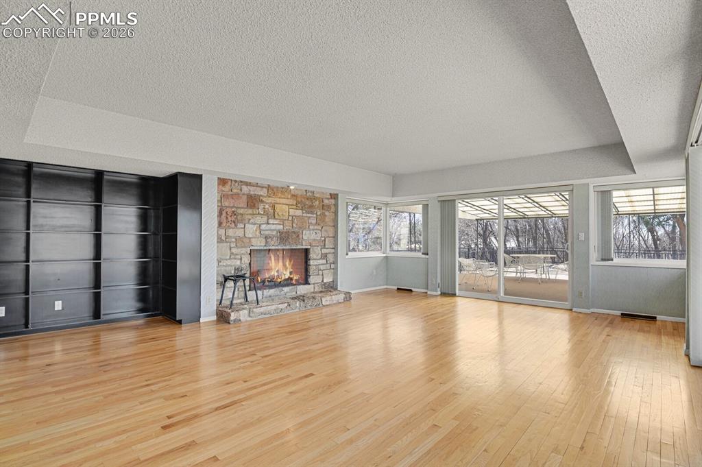 Image 16 of 49: Great/Family Room w/built-in bookshelves & wood burning fireplace. *Active