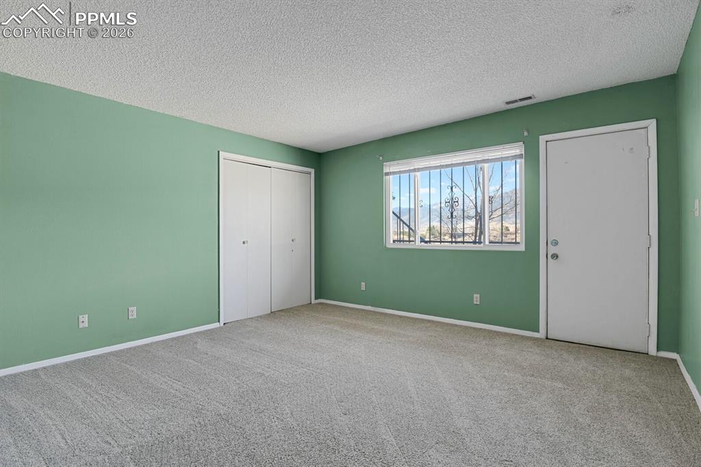 Image 34 of 49: Basement Bedroom w/walk-out door to back patio