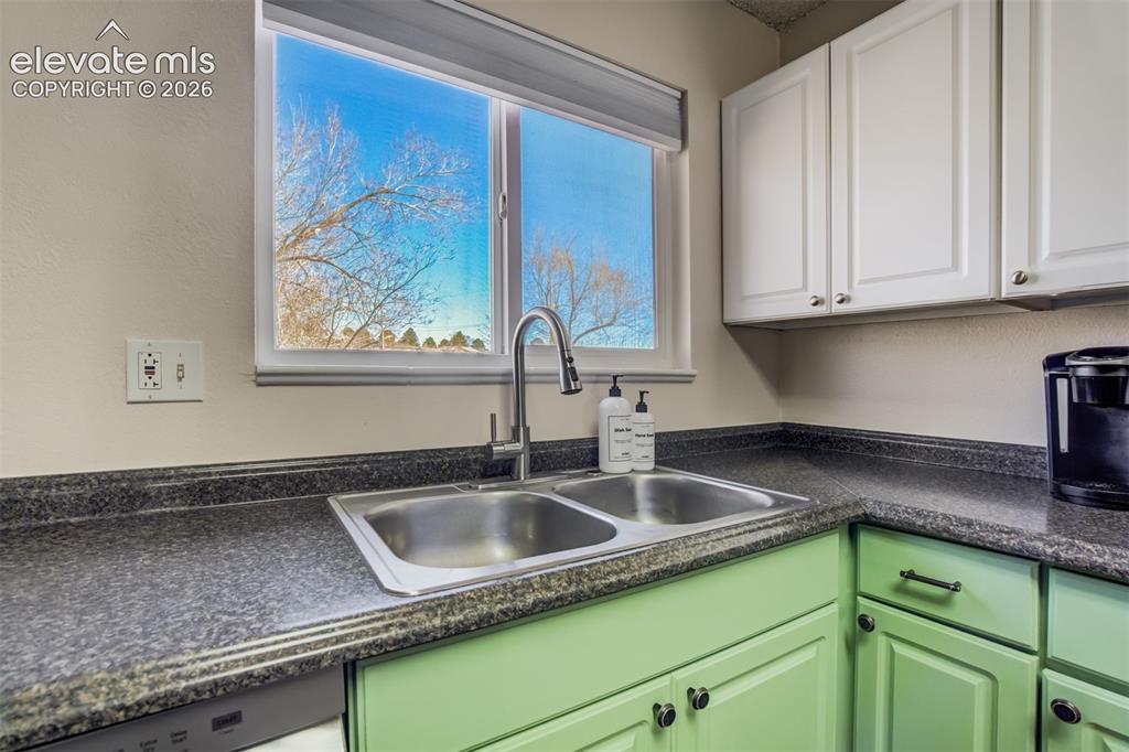 Image 10 of 50: Kitchen area featuring a window above a stainless steel double-basin sink w