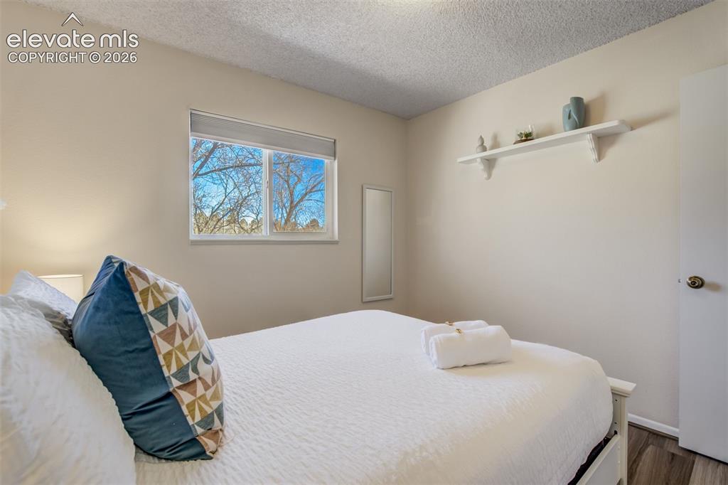Image 17 of 50: Window with a roller shade, textured ceiling, light-colored walls, wood-fin