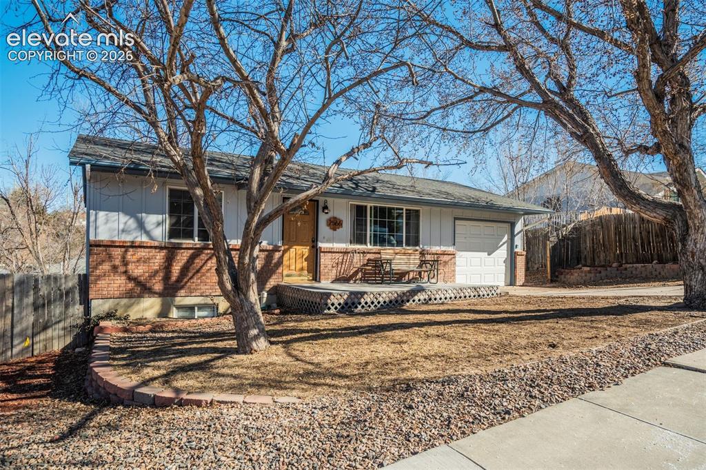 Image 2 of 50: Exterior featuring a brick facade, attached garage, and front porch with la